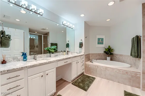 a spacious bathroom with a sink a large mirror and a bathtub