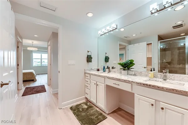 a spacious bathroom with a granite countertop sink a mirror and a shower