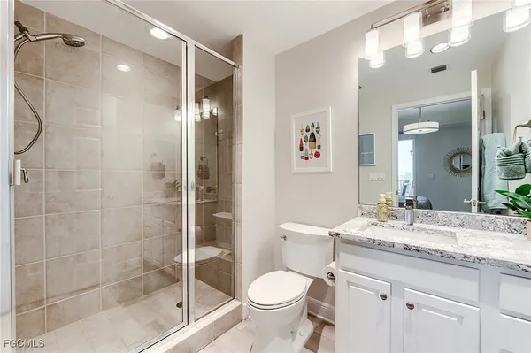 a bathroom with a granite countertop sink toilet and shower