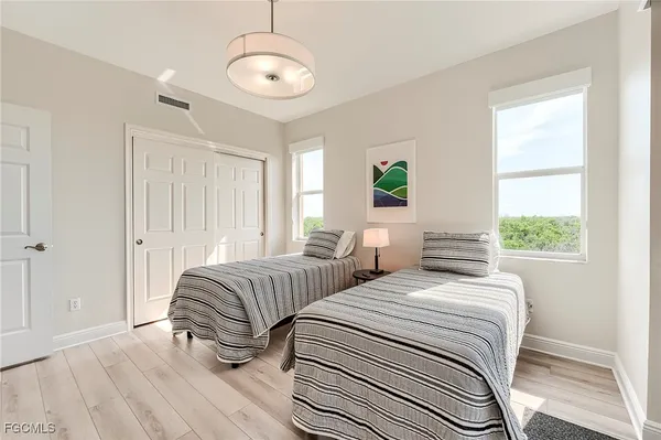 a bedroom with two beds and a chandelier