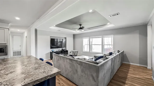 a living room with stainless steel appliances granite countertop a couch and a refrigerator