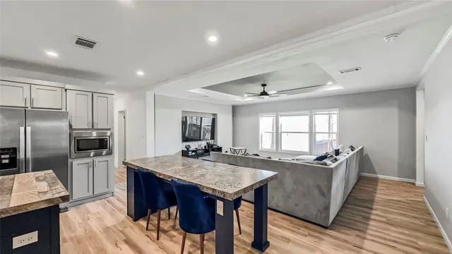 a kitchen with granite countertop a center island and stainless steel appliances
