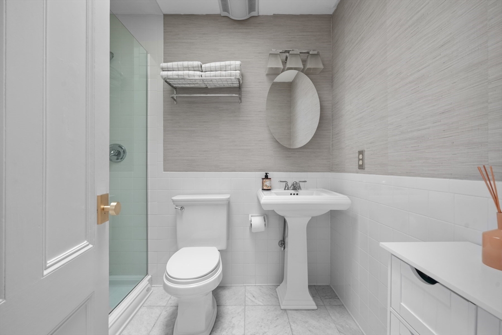 129 Beacon Street, Unit PH Boston, MA 02116 - Photo 24 of 40 a bathroom with a sink toilet and a mirror