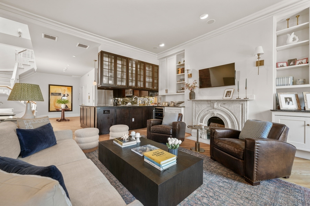 129 Beacon Street, Unit PH Boston, MA 02116 - Photo 6 of 40 a living room with furniture a fireplace and a flat screen tv