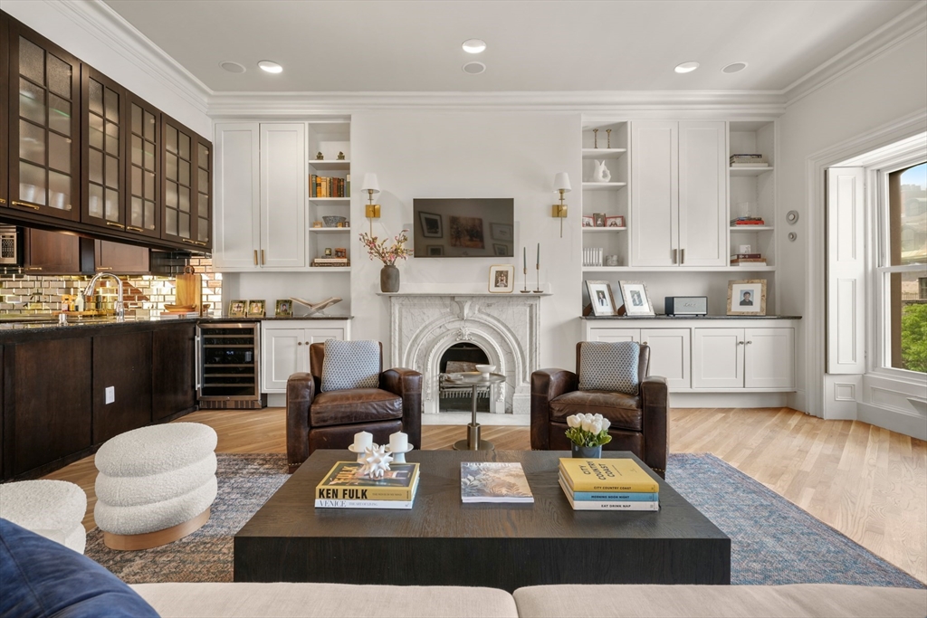 129 Beacon Street, Unit PH Boston, MA 02116 - Photo 10 of 40 a living room with furniture a flat screen tv and a fireplace