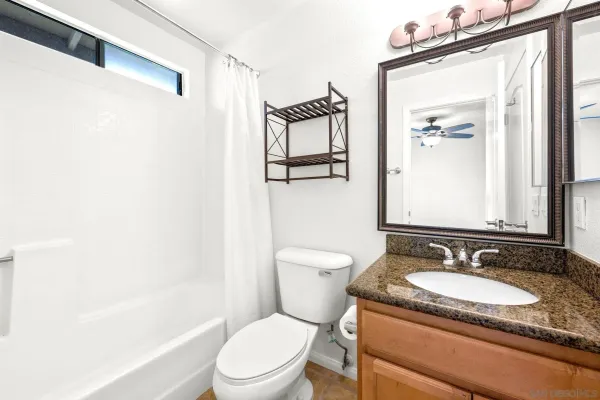a bathroom with a granite countertop sink toilet and shower