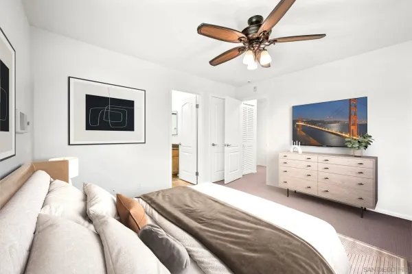 a bedroom with a bed a dresser and flat screen tv