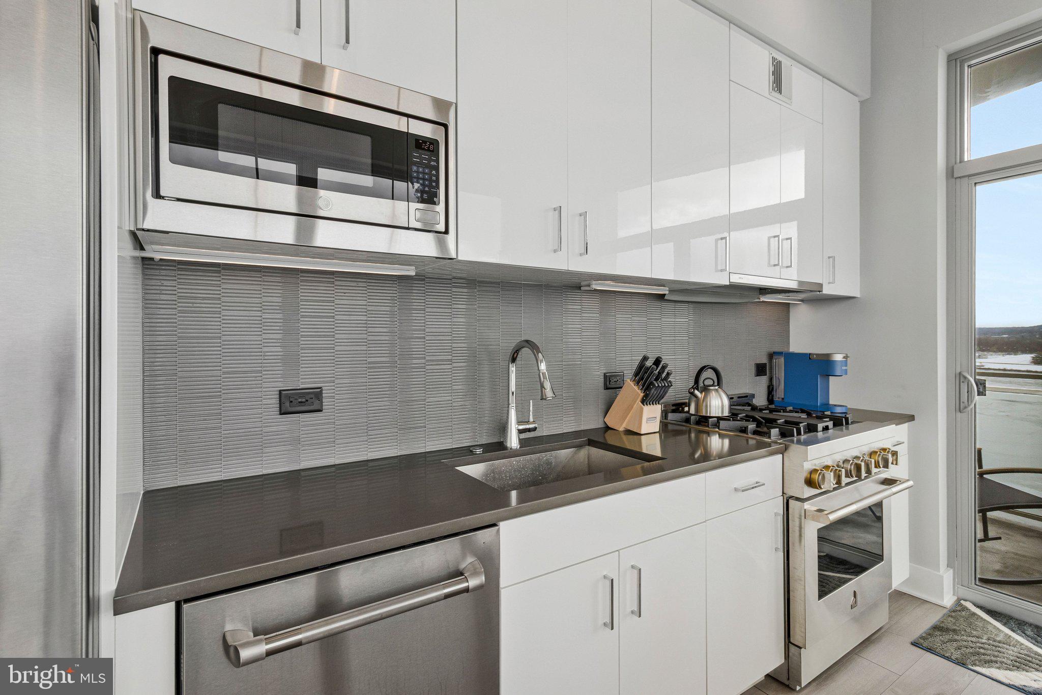 88 V Street Southwest, Unit 801 Washington, DC 20024 - Photo 18 of 58 a kitchen with stainless steel appliances granite countertop a sink a stove and cabinets