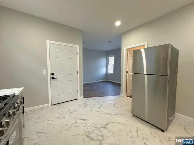 a view of kitchen with refrigerator and wooden floor