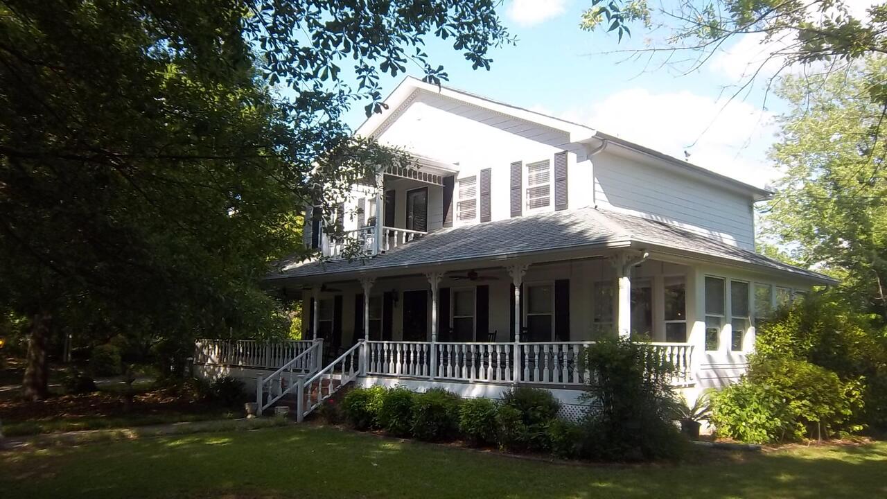 2728 Sunday Road Stockbridge, GA 30281 - Photo 1 of 1 a view of a white house next to a yard with plants and trees