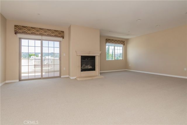 an empty room with windows and fireplace