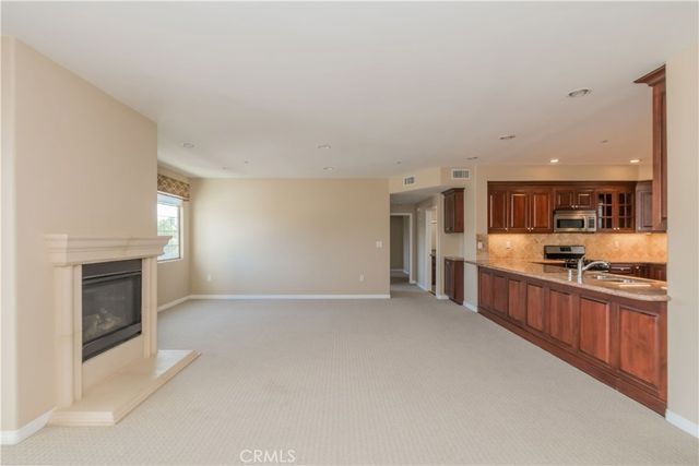 a view of kitchen with stainless steel appliances granite countertop a sink and cabinets