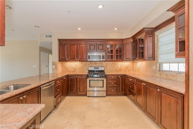 a kitchen with stainless steel appliances granite countertop a stove and a sink