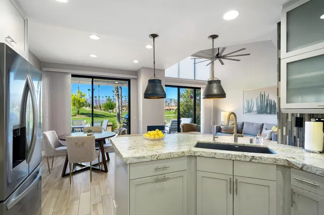 a kitchen with sink refrigerator dining table and chairs