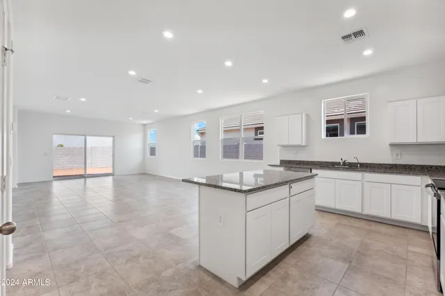 a kitchen with granite countertop a sink and cabinets
