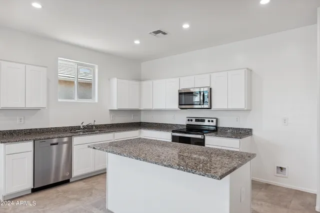a kitchen with stainless steel appliances granite countertop a sink stove and microwave