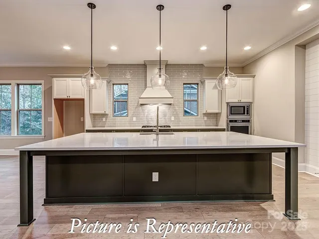 a kitchen with stainless steel appliances kitchen island granite countertop a sink and a stove