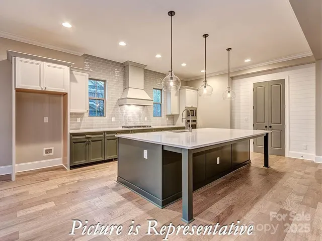 a kitchen with kitchen island stainless steel appliances a sink stove and cabinets