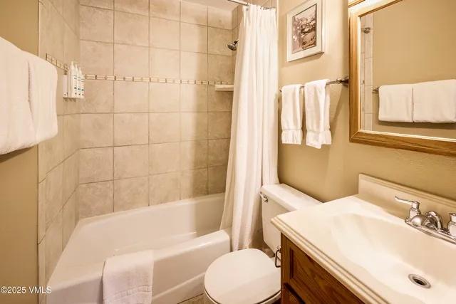 a bedroom with two beds and ceiling fan