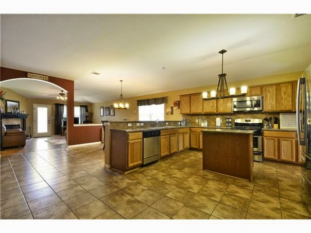 11612 Timber Heights Drive Austin, TX 78754 - Photo 7 of 28 An open-concept layout creates an effortless flow between the inviting kitchen and living spaces.