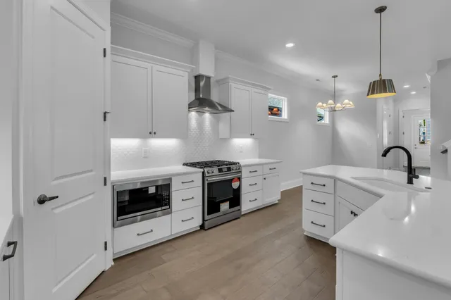 a stove sitting inside of a kitchen with white cabinets