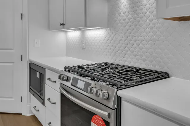 a kitchen with a sink a stove and a fireplace with wooden floor