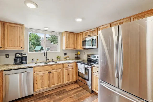 a kitchen with granite countertop a sink stove top oven and cabinets
