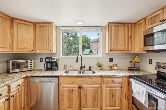 a kitchen with granite countertop a refrigerator stove and microwave