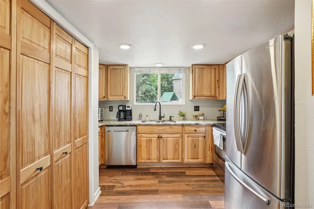 a view of a kitchen with wooden floor and outdoor space