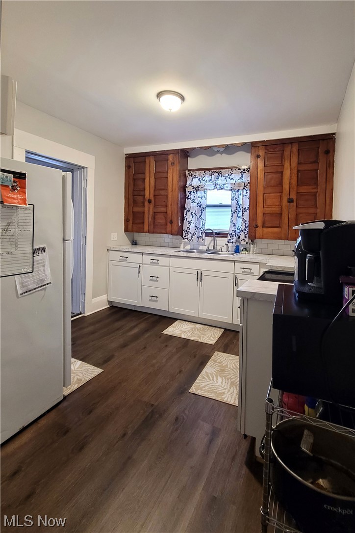 447 Cherry Road Northwest Massillon, OH 44647 - Photo 9 of 25 Kitchen with white fridge, sink, tasteful backsplash, white cabinets, and dark hardwood / wood-style floors