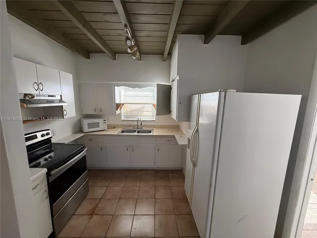 a kitchen with a refrigerator and a sink
