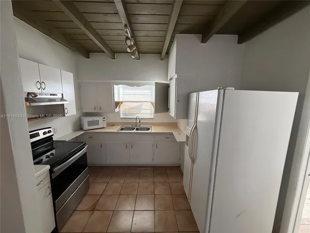 a kitchen with a refrigerator and a sink