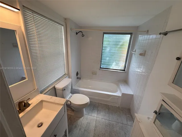 a bathroom with a sink a toilet a tub and shower