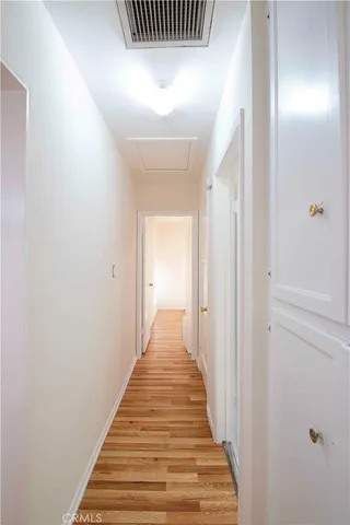 a view of a hallway with wooden floor and stairs