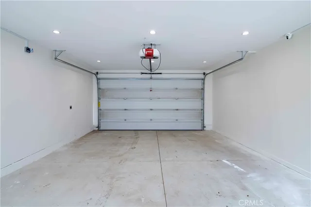 a room with a chandelier fan and wooden floor