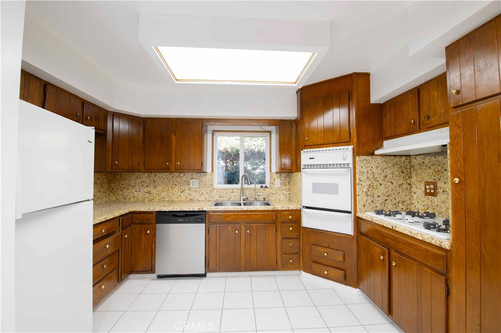 6417 White Oak Avenue Reseda, CA 91335 - Photo 7 of 50 a kitchen with stainless steel appliances granite countertop a refrigerator and a stove top oven