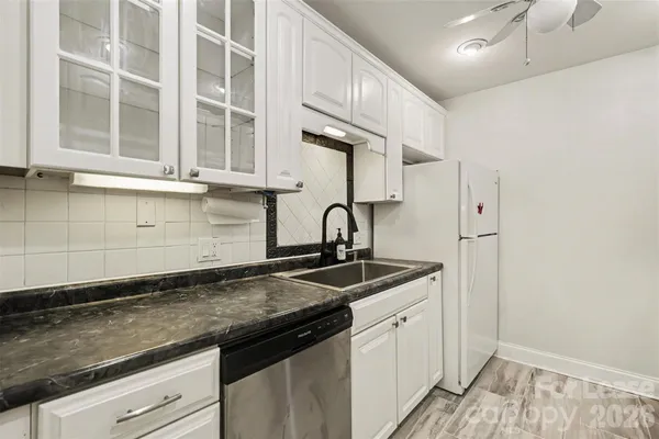 a kitchen with granite countertop a sink and cabinets