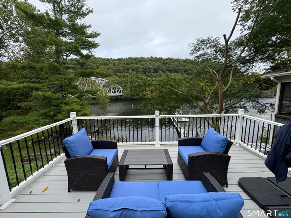 a roof deck with couches and wooden fence