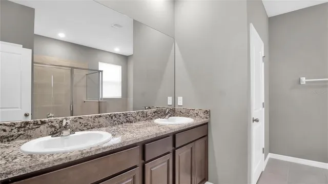 a bathroom with a granite countertop sink and a mirror