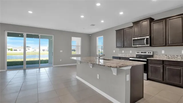 a kitchen with stainless steel appliances granite countertop a stove top oven a sink a counter space and cabinets