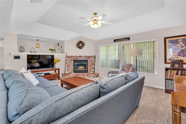 a living room with furniture a flat screen tv and a fireplace