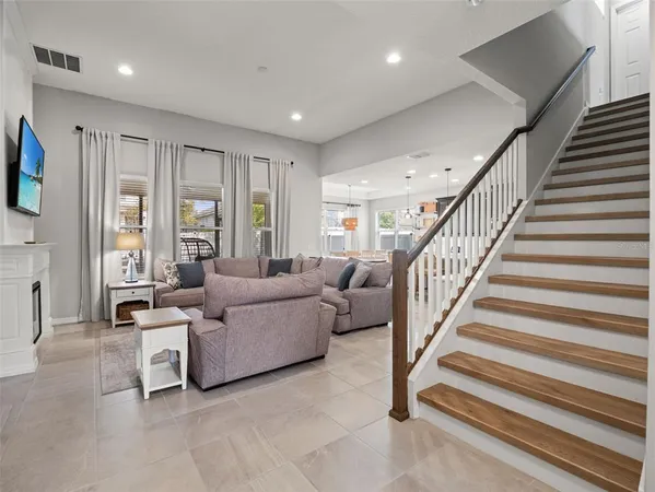 a living room with furniture a fireplace and a large window