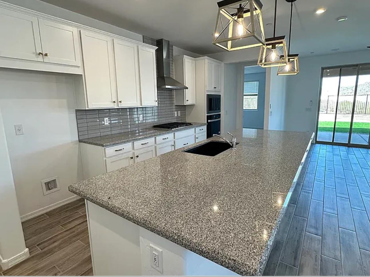 13302 West Eagle Feather Road Peoria, AZ 85383 - Photo 5 of 12 a kitchen with stainless steel appliances granite countertop a sink a stove and a wooden floors