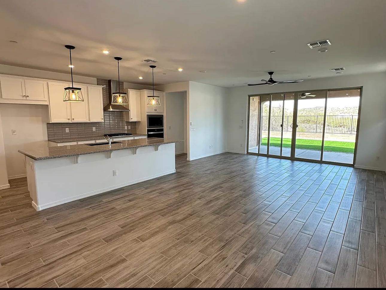 13302 West Eagle Feather Road Peoria, AZ 85383 - Photo 7 of 12 a large kitchen with stainless steel appliances granite countertop a large counter top a sink and a large window