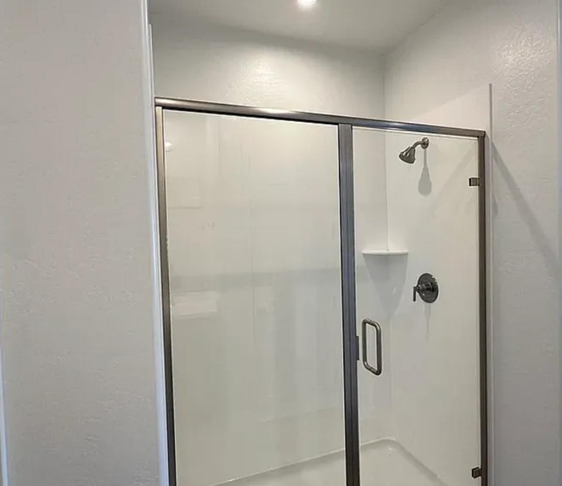 13302 West Eagle Feather Road Peoria, AZ 85383 - Photo 8 of 12 a bathroom with a glass shower door