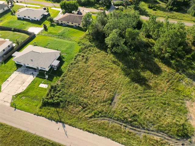 an aerial view of a residential houses with yard