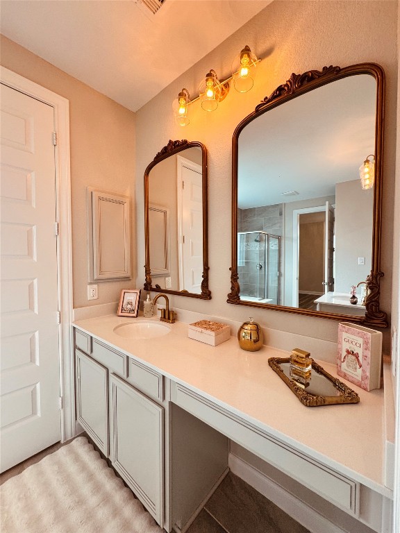2023 Pine Ledge Road Pearland, TX 77089 - Photo 12 of 29 This bathroom features a double vanity with elegant framed mirrors and vintage-style lighting. The light-colored cabinetry and countertop provide a clean, classic look, complemented by decorative accents.