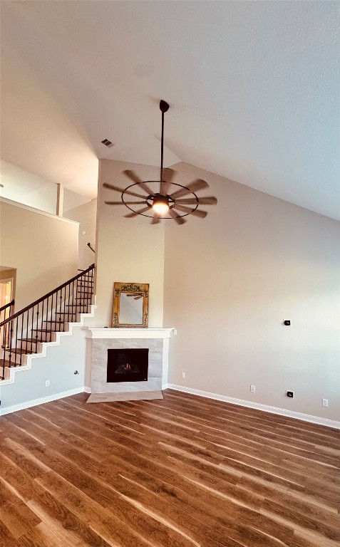 2023 Pine Ledge Road Pearland, TX 77089 - Photo 29 of 29 This spacious living area features high ceilings, a modern ceiling fan, and a cozy fireplace. It has elegant wood flooring and an open staircase, adding a touch of sophistication.