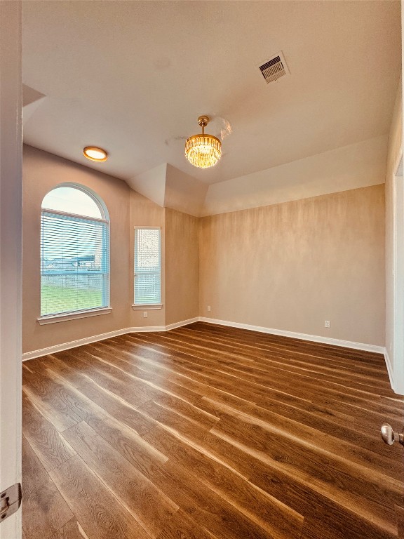 2023 Pine Ledge Road Pearland, TX 77089 - Photo 10 of 29 Bright master bedroom with elegant wood flooring and soft beige walls. Features a stylish chandelier, high ceiling, and two large windows for natural light.