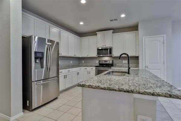 a kitchen with stainless steel appliances granite countertop a refrigerator sink and stove